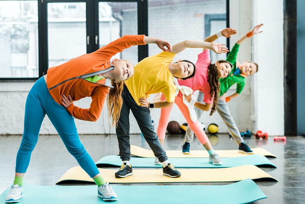 Preteen kids doing sport exercise in gym